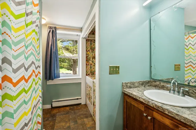a bathroom with a granite countertop sink a mirror and a shower