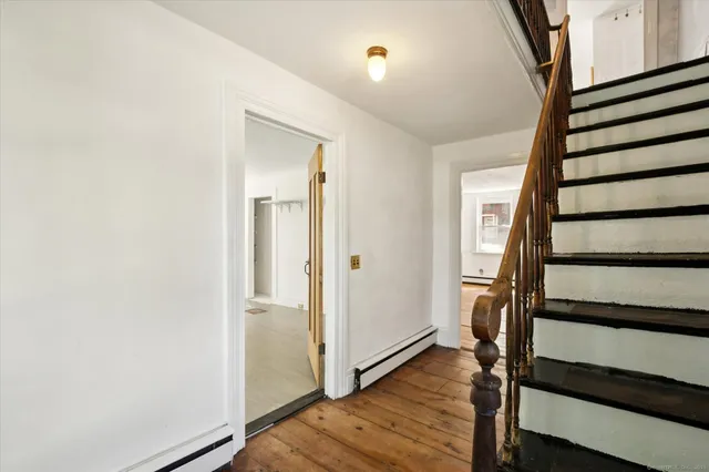 a view of a hallway with wooden floor and entryway