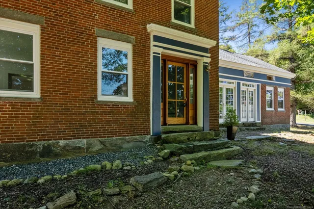 a view of a brick house with a yard