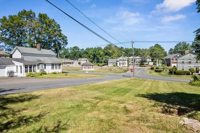 a view of swimming pool with lawn chairs and plants