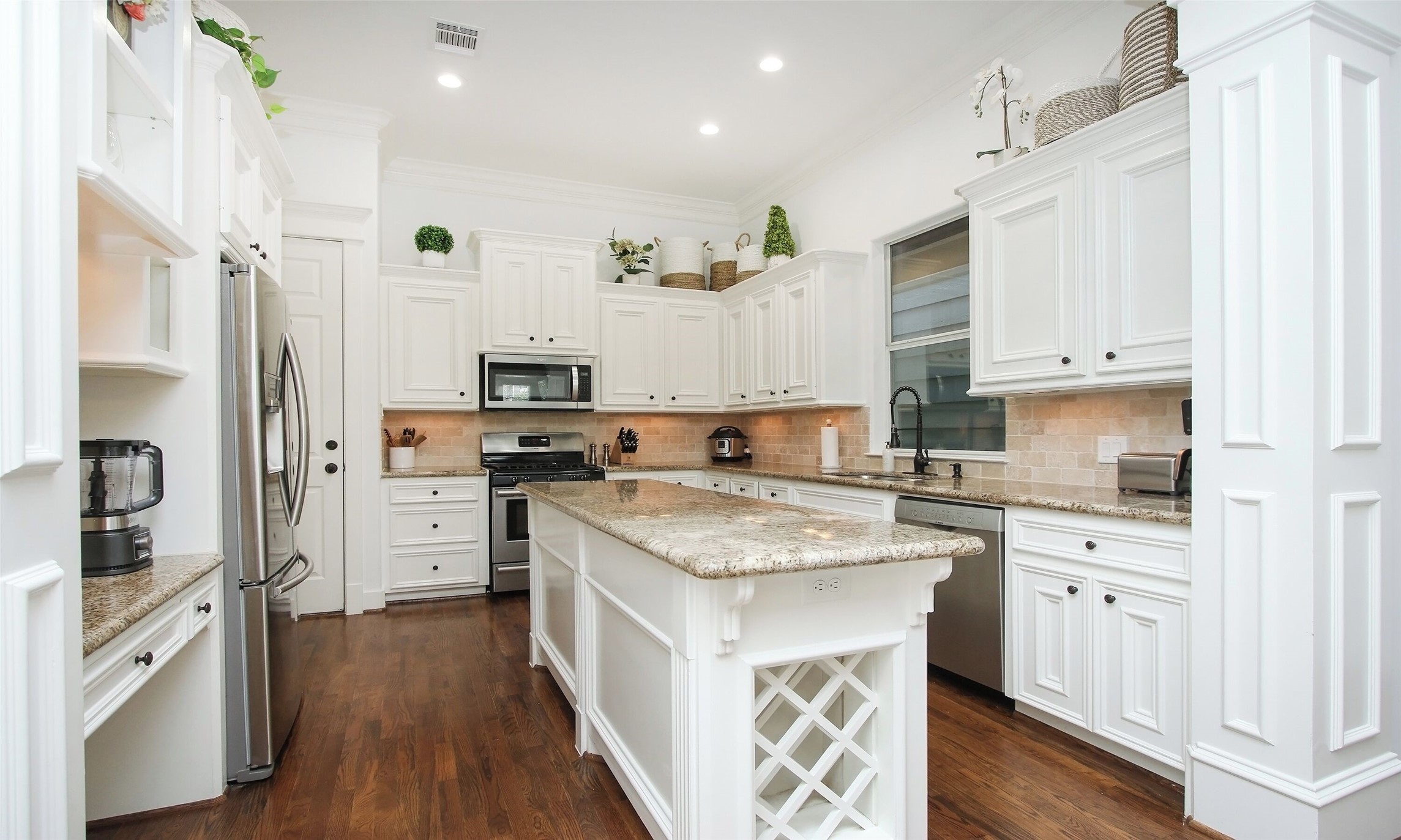 1330 West 25th Street, Unit C Houston, TX 77008 - Photo 11 of 30 a kitchen with stainless steel appliances granite countertop a stove top oven a refrigerator a sink and dishwasher with white cabinets