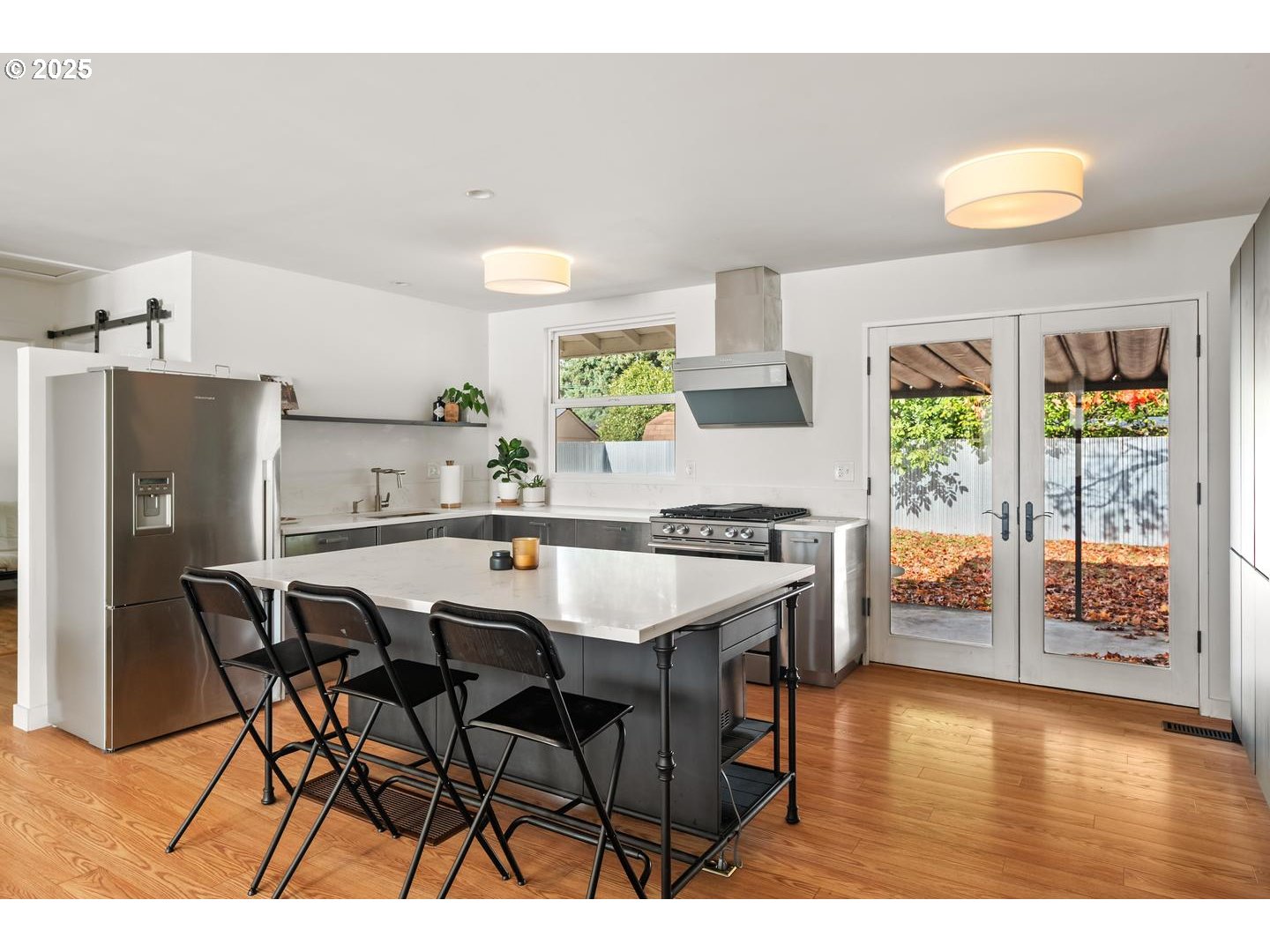 8629 Northeast Clackamas Street Portland, OR 97220 - Photo 14 of 32 a dining hall with stainless steel appliances a dining table and chairs with wooden floor