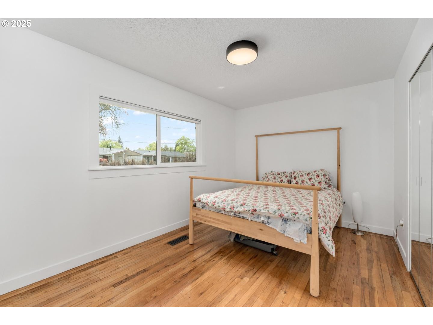 8629 Northeast Clackamas Street Portland, OR 97220 - Photo 22 of 32 a bed sitting in a bedroom next to a window