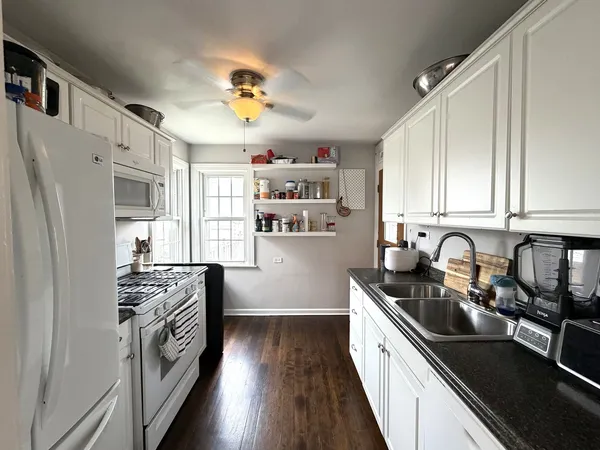 a kitchen with stainless steel appliances a sink a stove a refrigerator cabinets and a window