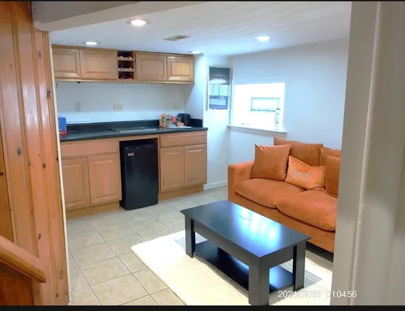 a living room with stainless steel appliances kitchen island granite countertop furniture and a view of kitchen