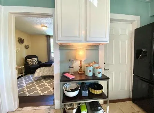a bedroom with a bed and a lamp on dresser