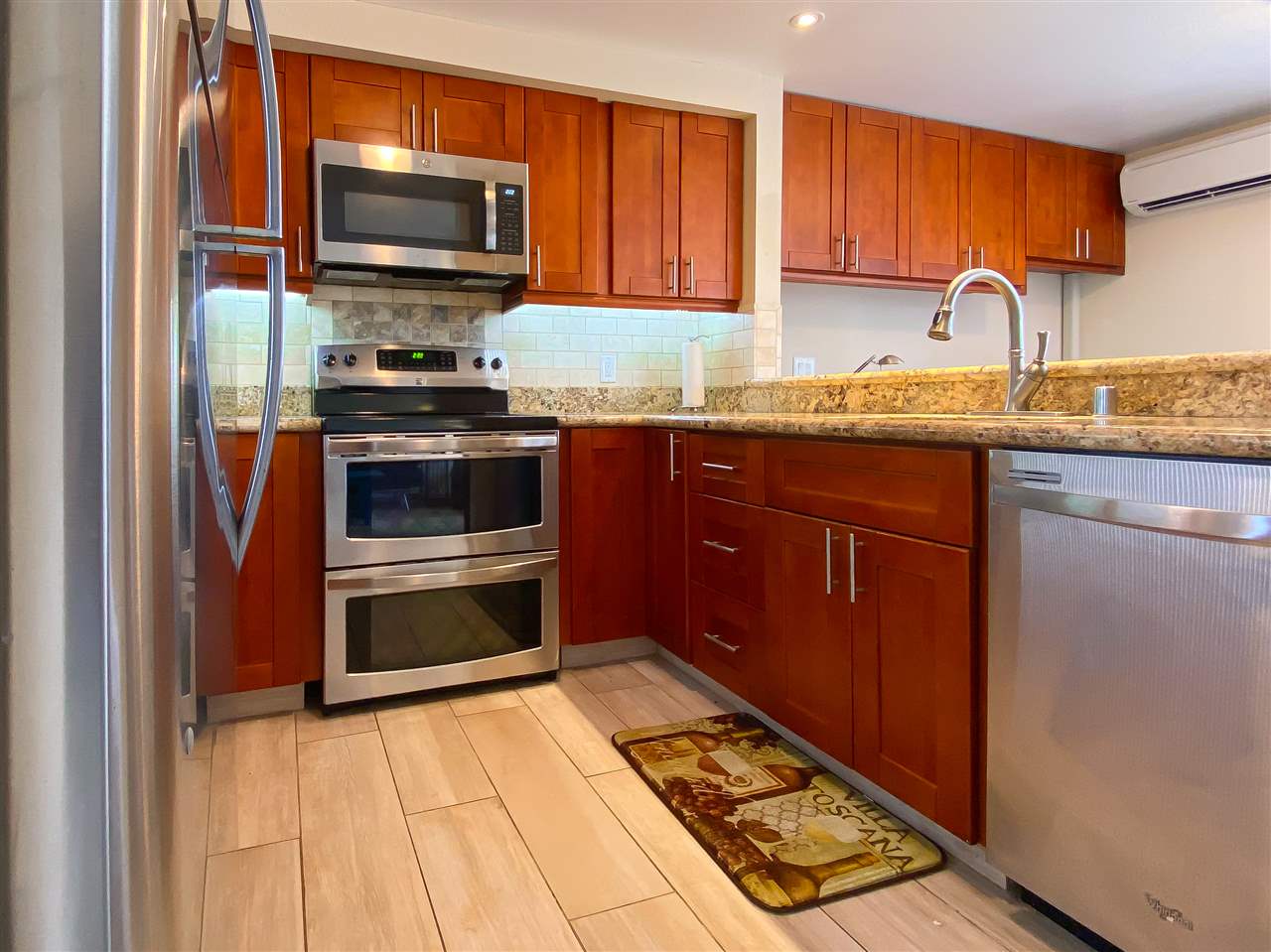 2747 South Kihei Road, Unit A201 Kihei, HI 96753 - Photo 3 of 29 a kitchen with granite countertop a stove top oven a sink and dishwasher a oven with wooden cabinets