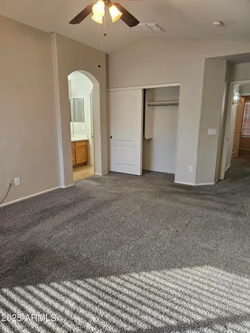 an empty room with a mirror and a chandelier fan