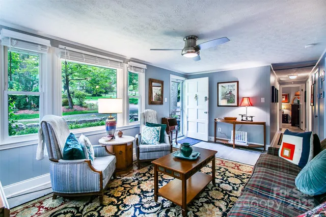 a living room with patio furniture and a floor to ceiling window