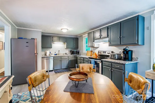a kitchen with granite countertop a sink cabinets and stainless steel appliances