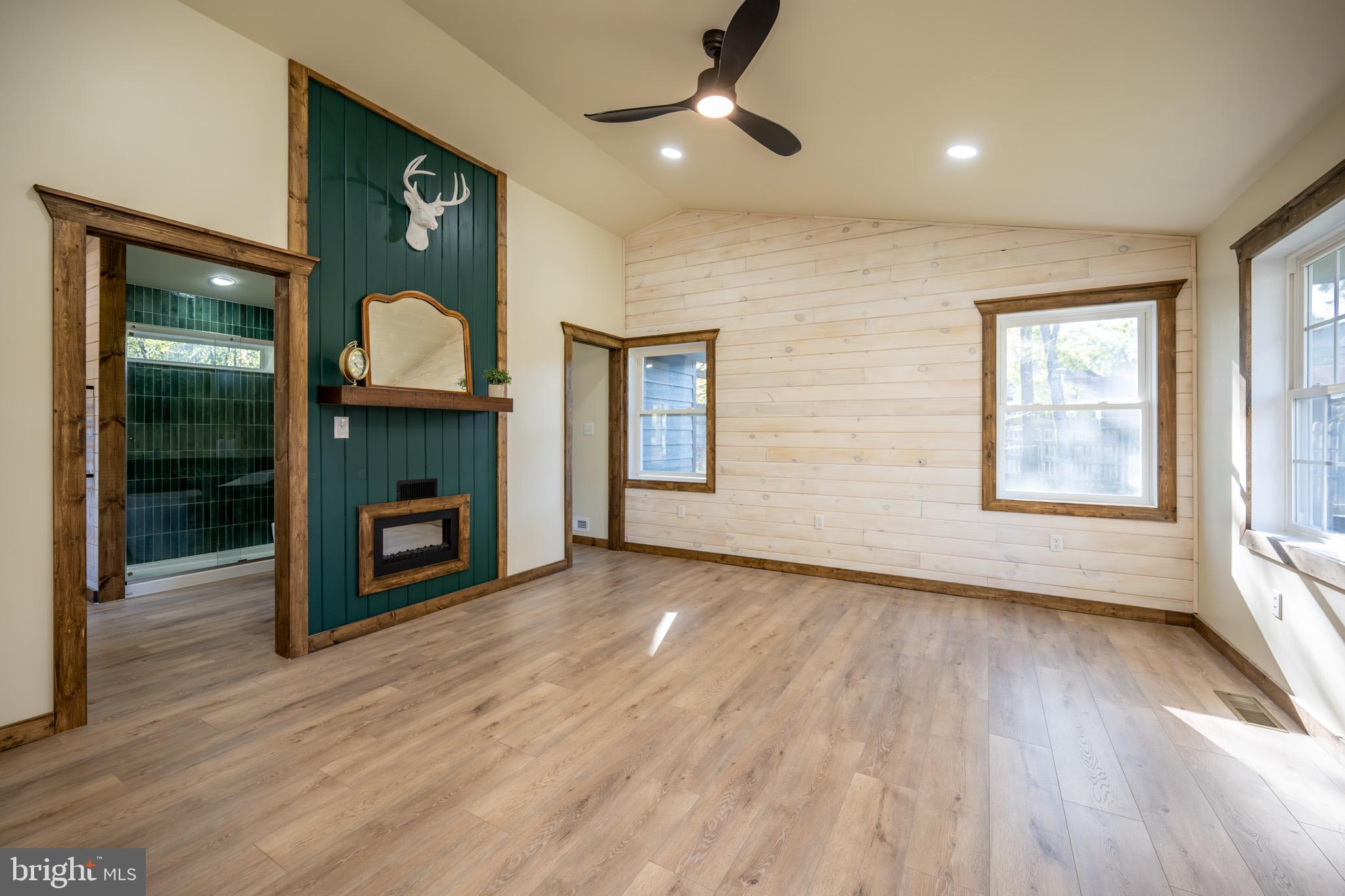 3456 Glendale Road Swanton, MD 21561 - Photo 41 of 93 an empty room with wooden floor fireplace and windows