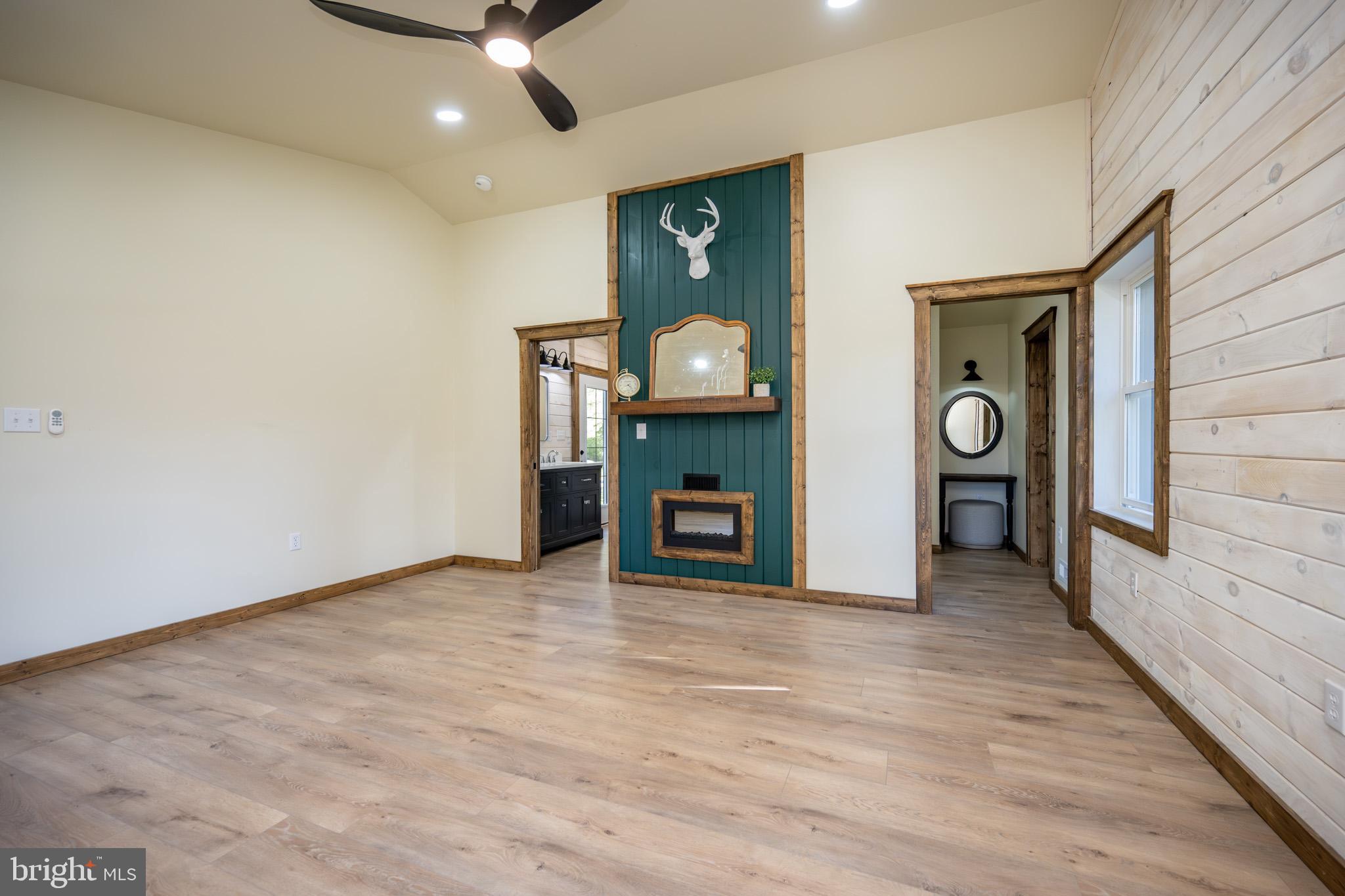 3456 Glendale Road Swanton, MD 21561 - Photo 43 of 93 a view of an empty room with a fireplace and a ceiling fan