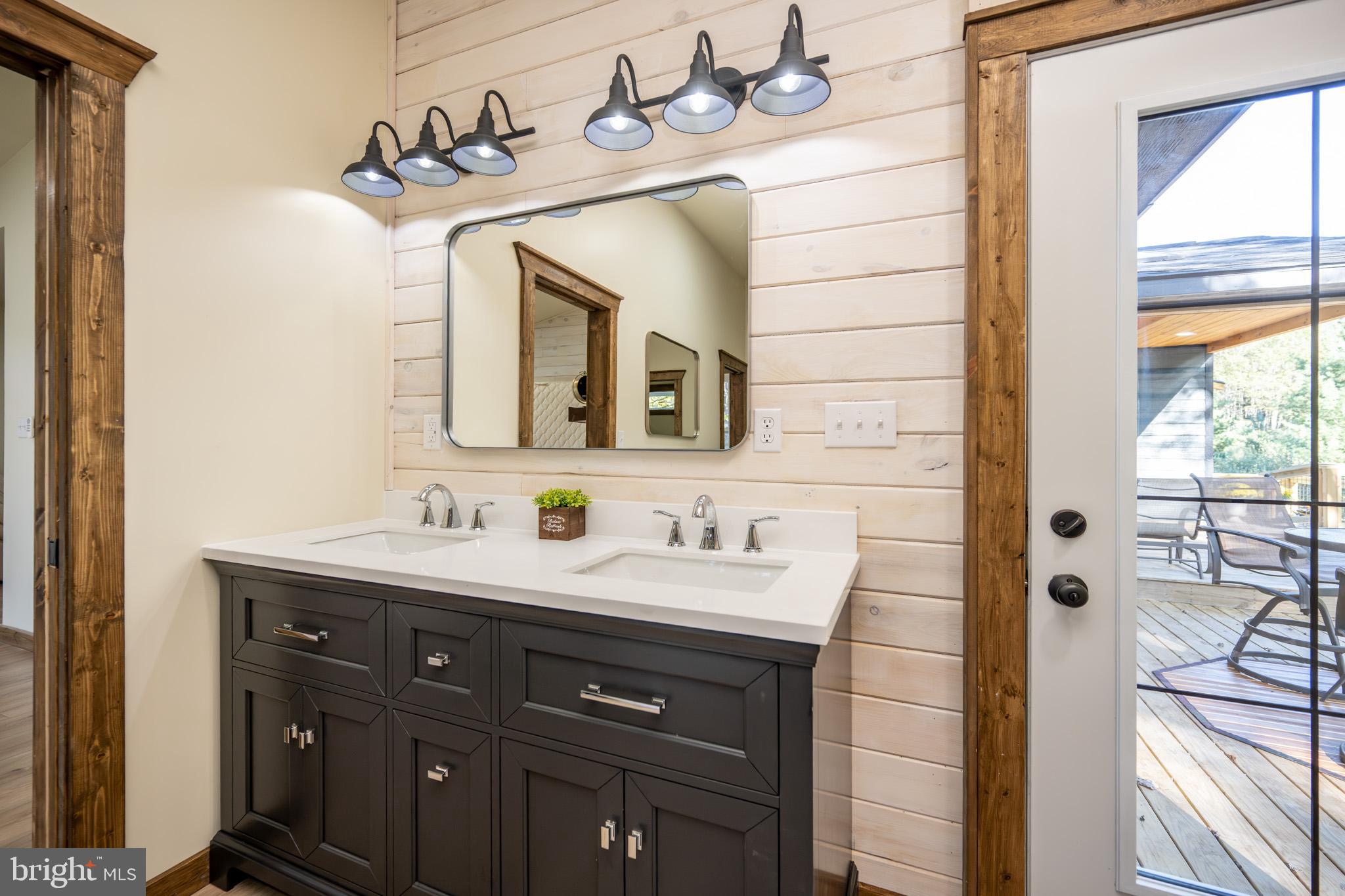 3456 Glendale Road Swanton, MD 21561 - Photo 54 of 93 a bathroom with a double vanity sink and a mirror