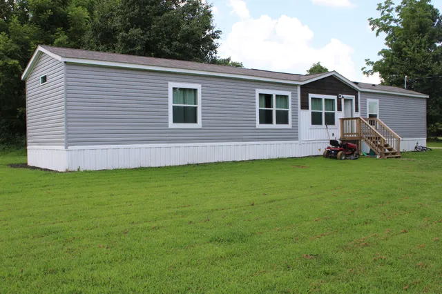 a view of a house with a yard and sitting area