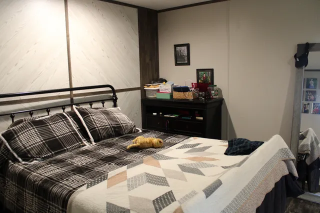 a bedroom with a bed and a mirror