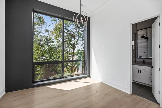 an empty room with large windows and a fireplace