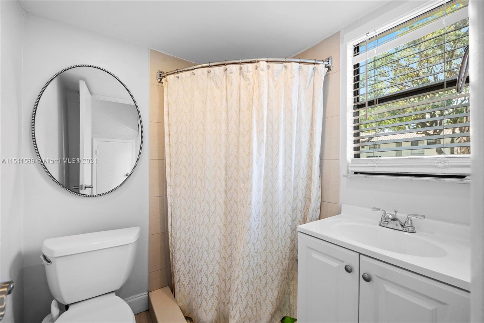 7200 Northwest 2nd Avenue, Unit 1250 Boca Raton, FL 33487 - Photo 20 of 57 a bathroom with a toilet a sink a mirror and a window