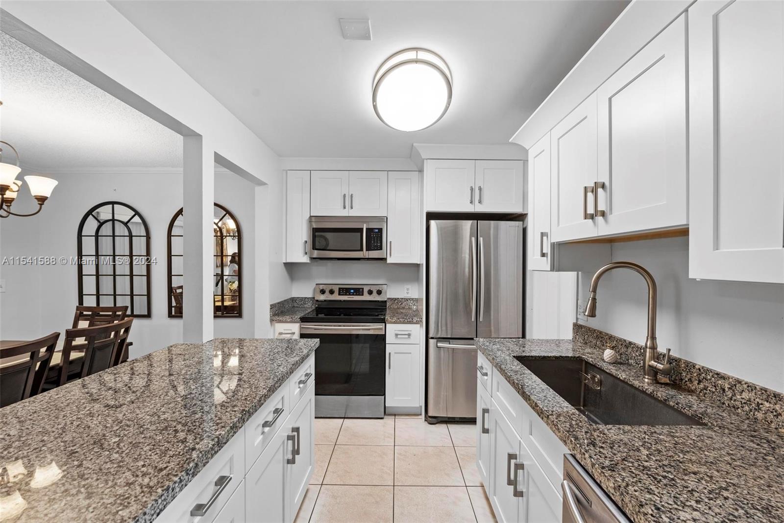 7200 Northwest 2nd Avenue, Unit 1250 Boca Raton, FL 33487 - Photo 3 of 57 a kitchen with stainless steel appliances granite countertop a stove a sink dishwasher a refrigerator and cabinets with wooden floor