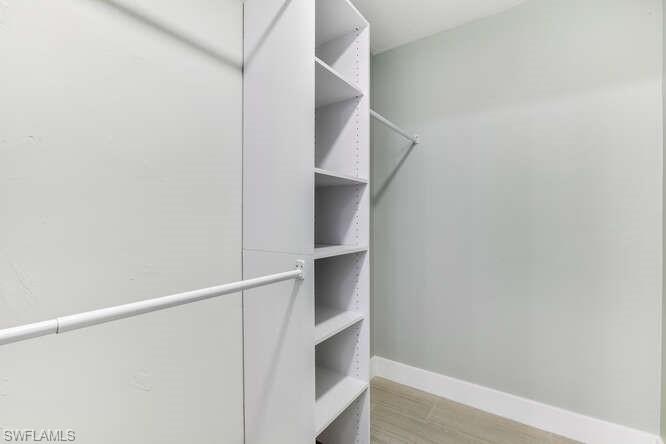 2876 West Crown Pointe Boulevard Naples, FL 34112 - Photo 12 of 36 Spacious walk-in closet with fresh paint, new LVT flooring and built-in storage/closet system