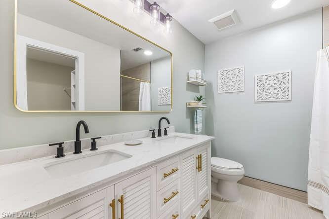 2876 West Crown Pointe Boulevard Naples, FL 34112 - Photo 13 of 36 Updated Master Bathroom featuring double vanity, new tile flooring, walk-in shower, and recessed lighting.