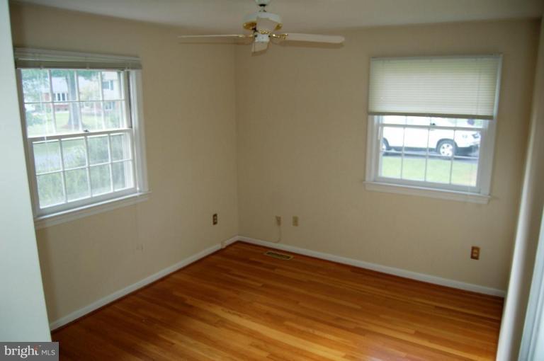 18809 Willow Grove Road Olney, MD 20832 - Photo 11 of 15 an empty room with wooden floor cabinet and windows