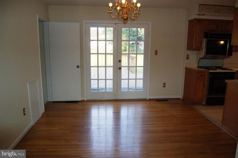 18809 Willow Grove Road Olney, MD 20832 - Photo 4 of 15 a view of an empty room with wooden floor and a window