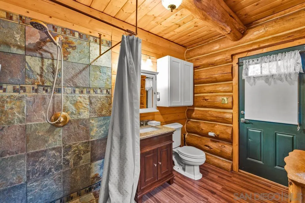 15469 Incapa Road Julian, CA 92036 - Photo 9 of 23 a bathroom with a granite countertop toilet a sink and shower