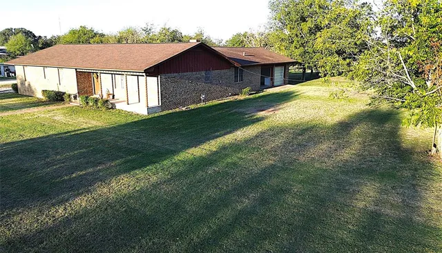 a view of a yard in front of a house with a large tree