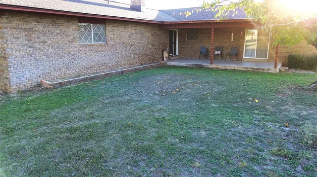 a view of a backyard with table and chairs and potted plants