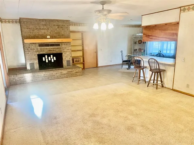 a view of a livingroom with furniture a fireplace and chandelier