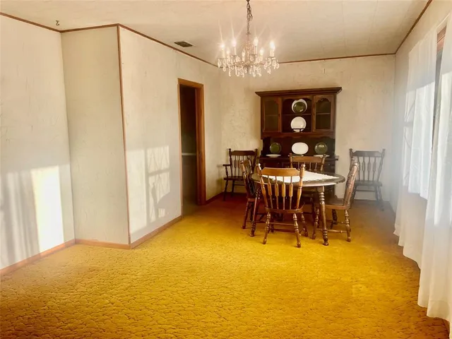a view of a dining room with furniture and chandelier