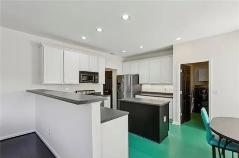 a kitchen with stainless steel appliances granite countertop a refrigerator and a stove top oven
