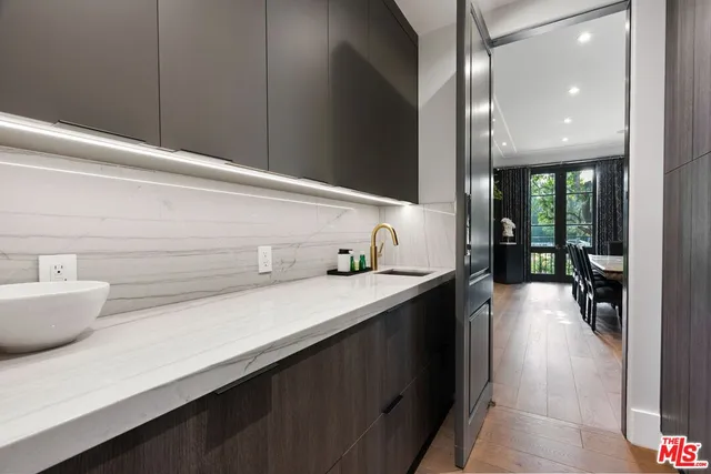 a hallway with a sink and cabinets