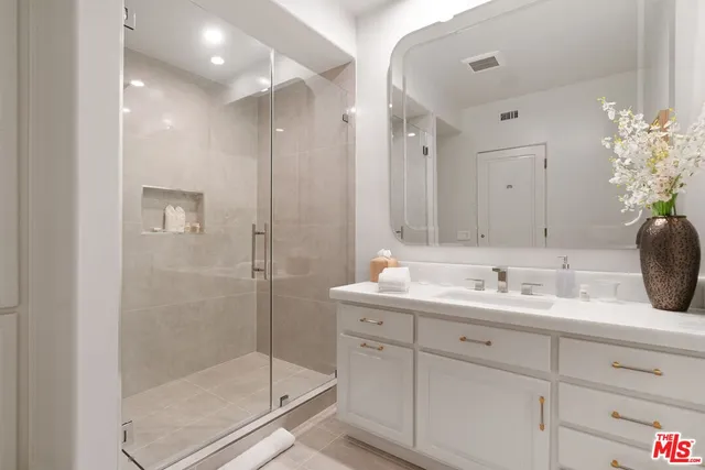 a bathroom with a shower sink and mirror