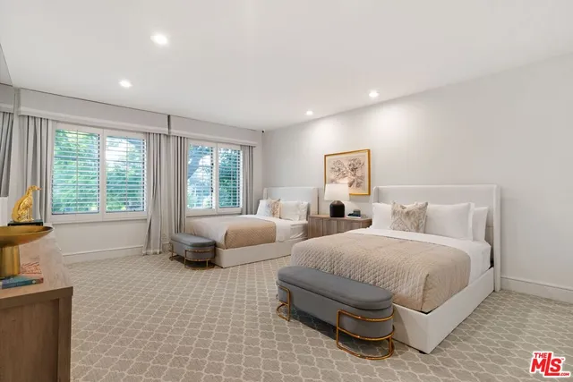 a spacious bedroom with a bed and glass window