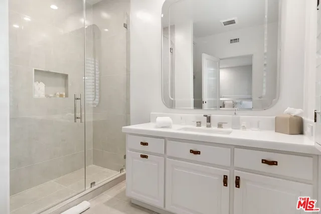 a bathroom with a shower sink vanity and mirror