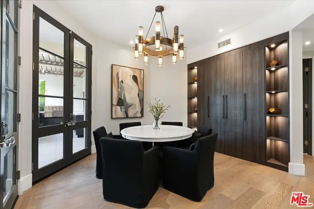 a dining room with wooden floor a chandelier a wooden table and chairs