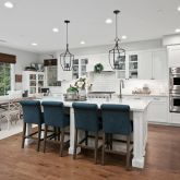 a dining room with stainless steel appliances kitchen island granite countertop a table chairs and a living room view