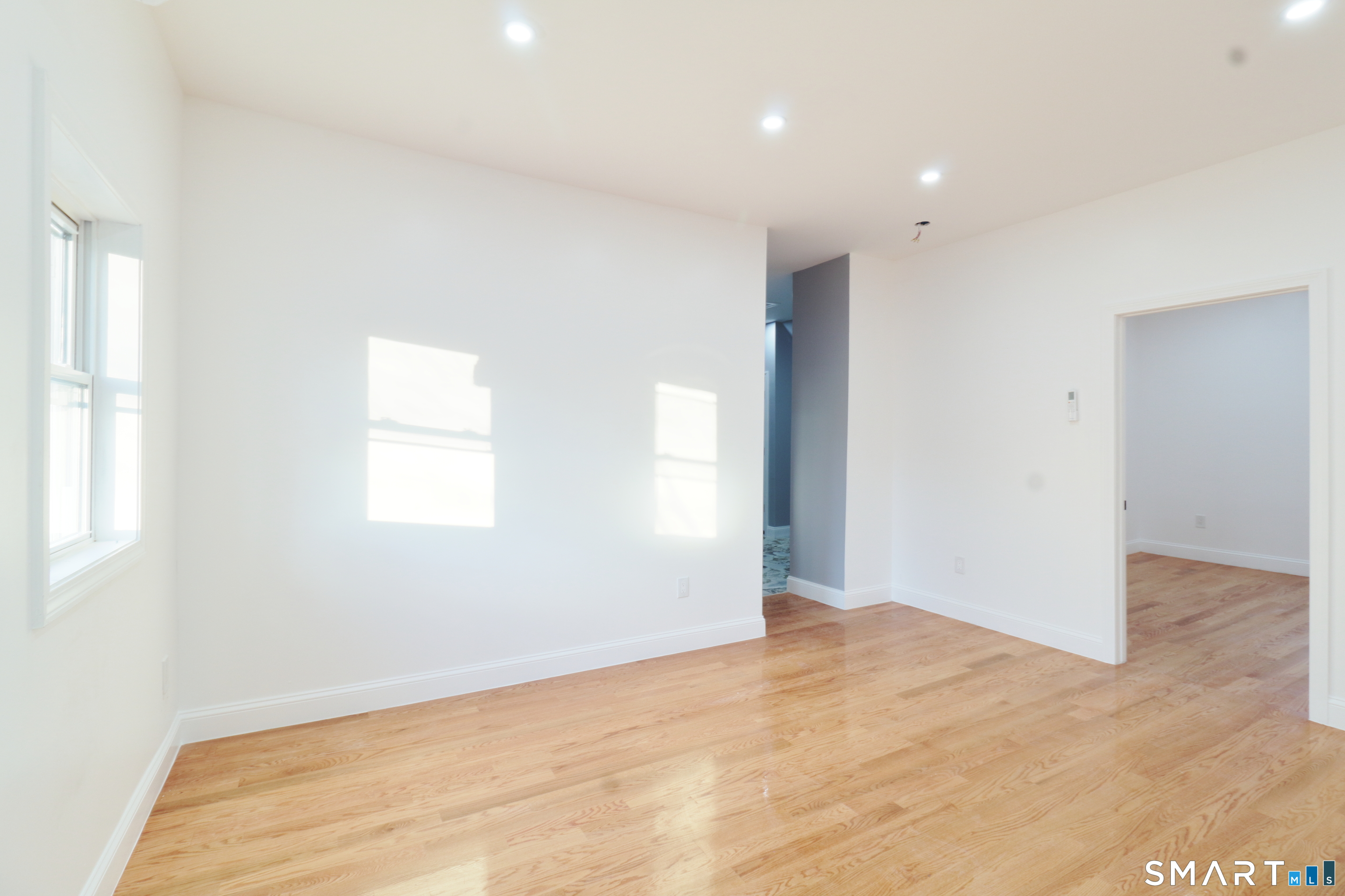 40 Elizabeth Street, Unit 3 Waterbury, CT 06704 - Photo 3 of 10 an empty room with wooden floor and windows