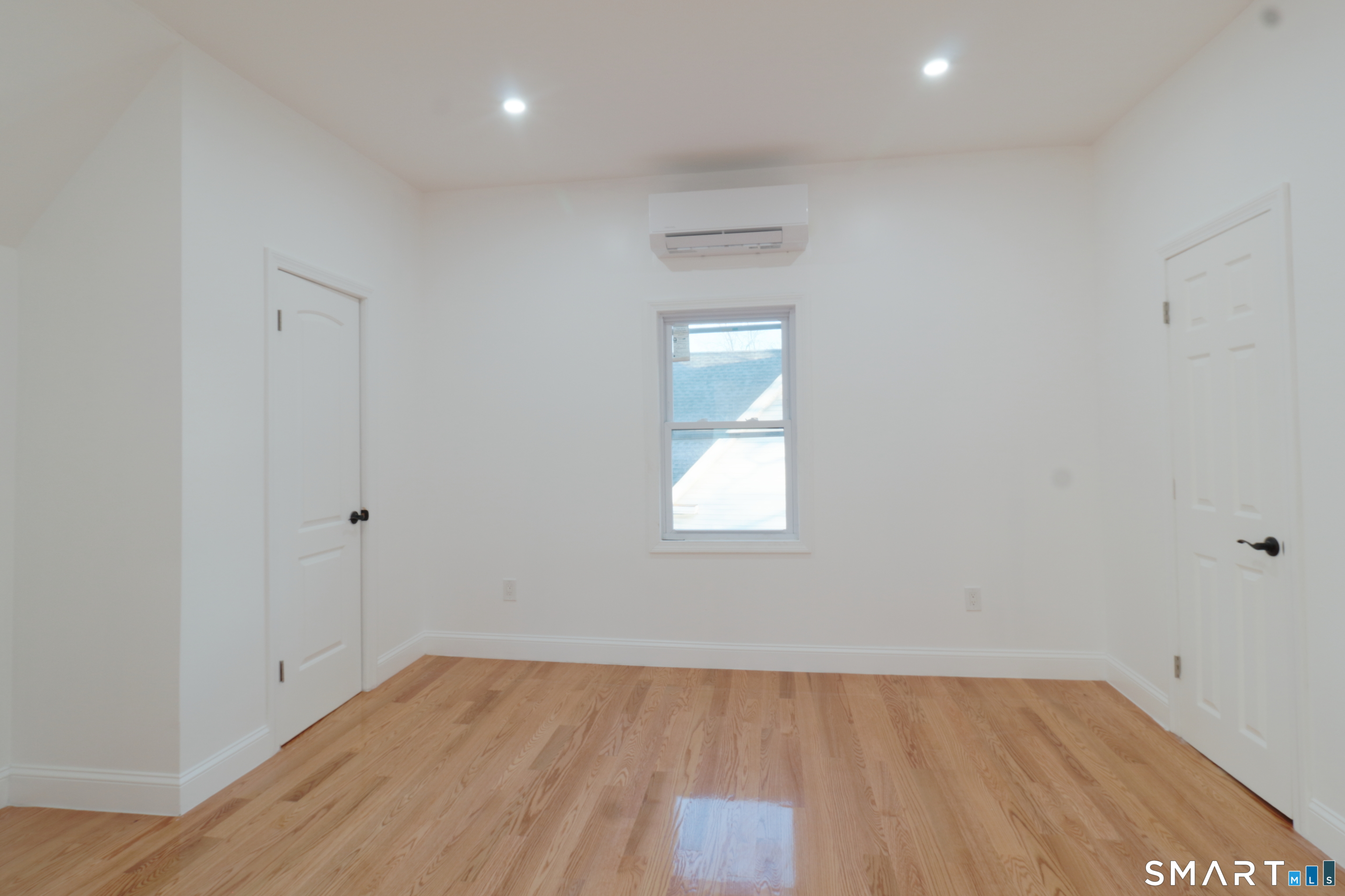 40 Elizabeth Street, Unit 3 Waterbury, CT 06704 - Photo 4 of 10 a view of an empty room with wooden floor and a window