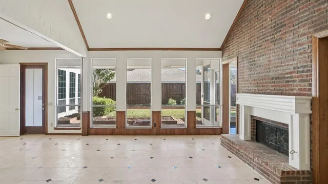 a living room with a fireplace and floor to ceiling windows