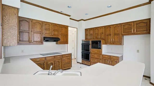 a kitchen with stainless steel appliances kitchen island granite countertop a refrigerator oven stove a sink and dishwasher