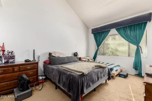 a bedroom with a bed and a flat tv screen on a dresser