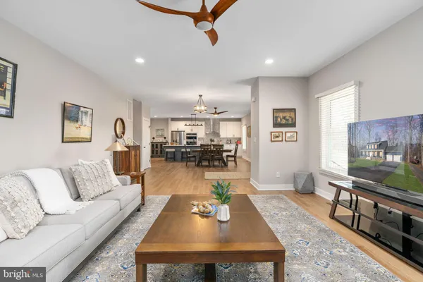 a kitchen with stainless steel appliances a sink stove and white cabinets with wooden floor