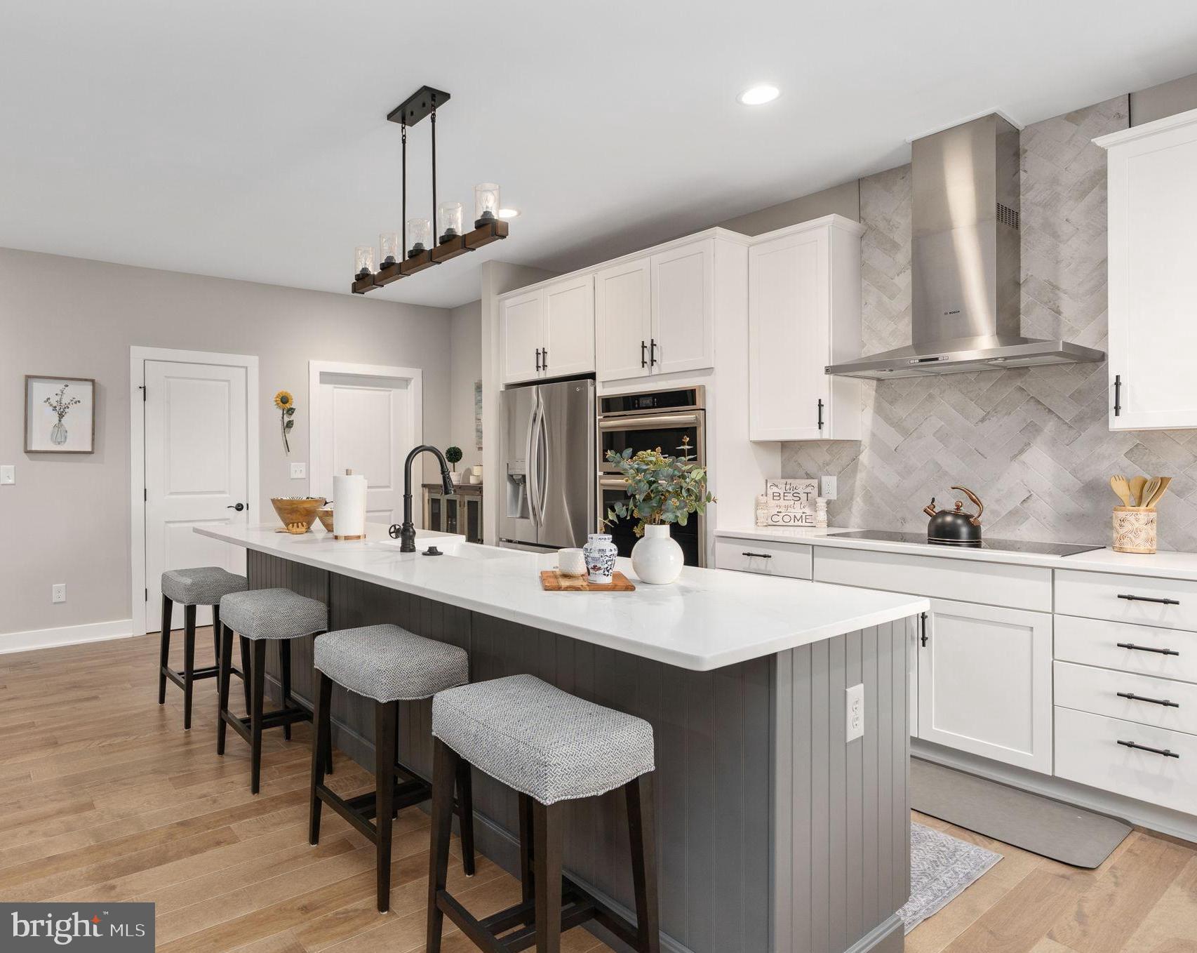 261 Washington Street Locust Grove, VA 22508 - Photo 15 of 69 a kitchen with stainless steel appliances a sink stove and white cabinets with wooden floor