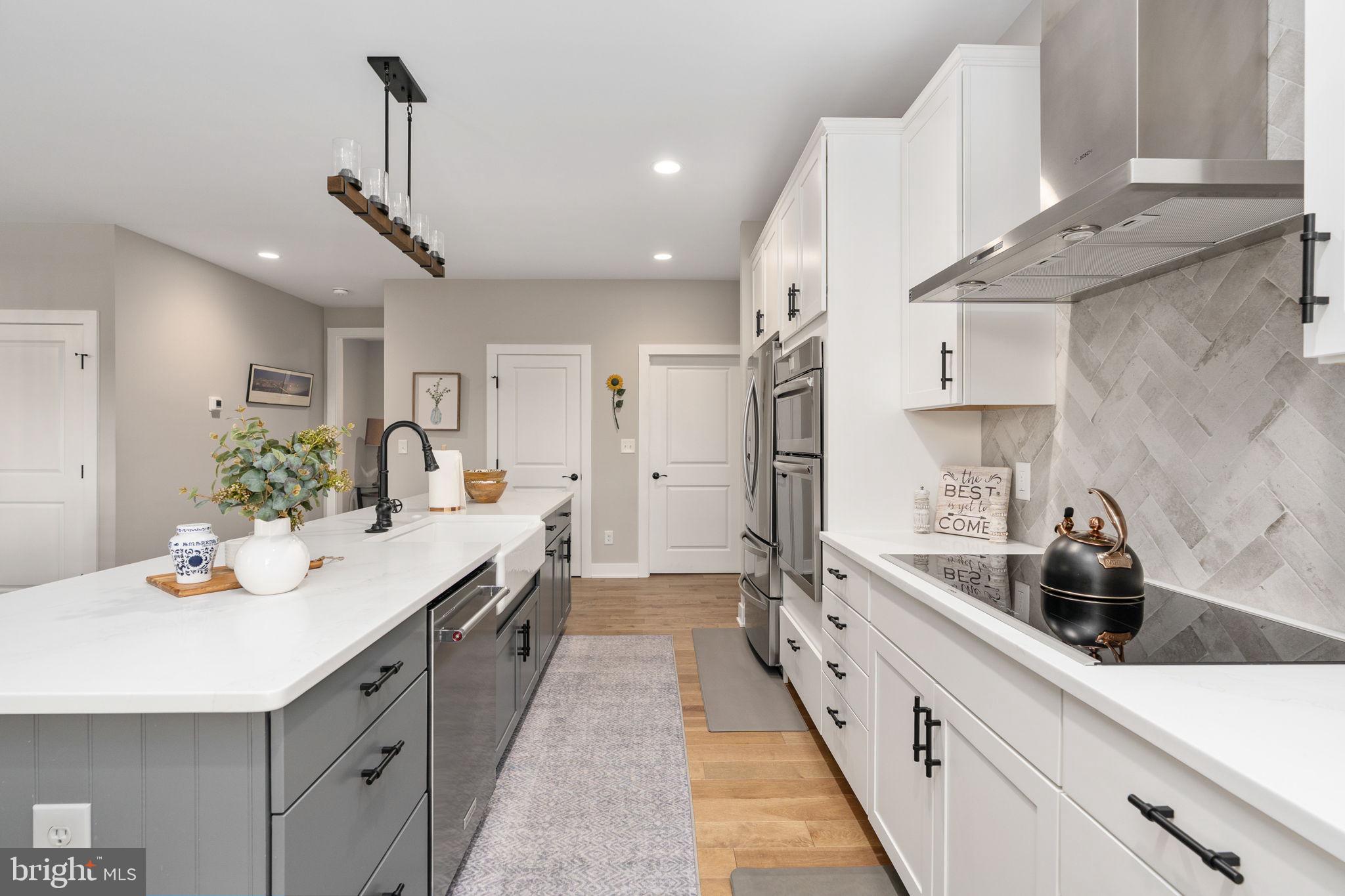 261 Washington Street Locust Grove, VA 22508 - Photo 17 of 69 a large white kitchen with stainless steel appliances lots of counter space and wooden floor