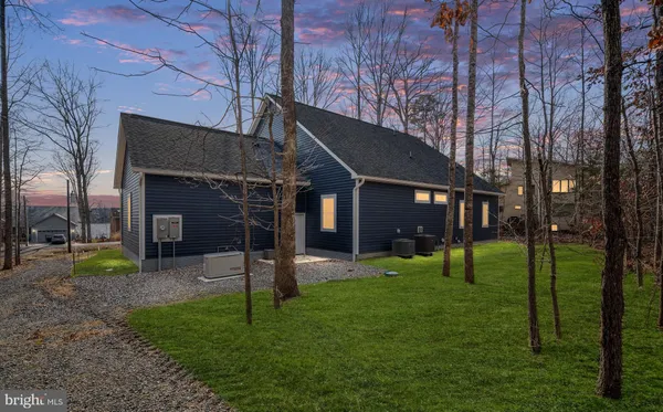 a view of a house with a yard and a tree