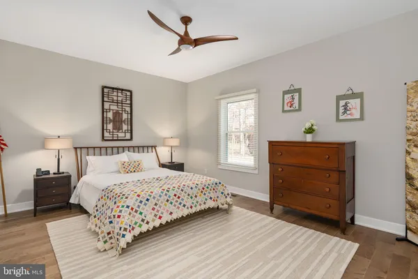 a bedroom with two bed and a ceiling fan