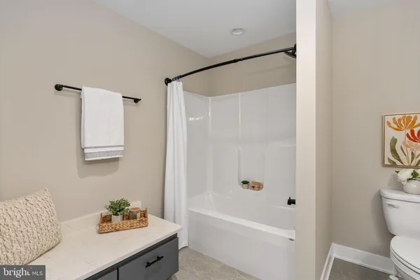 a view of a brick house next to a yard with big trees