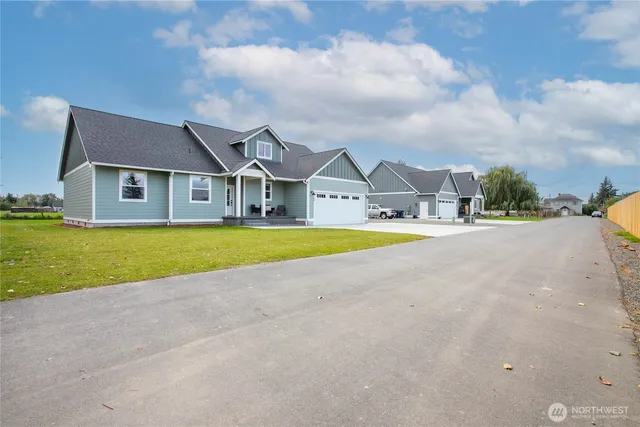 a view of a house with a big yard and large trees